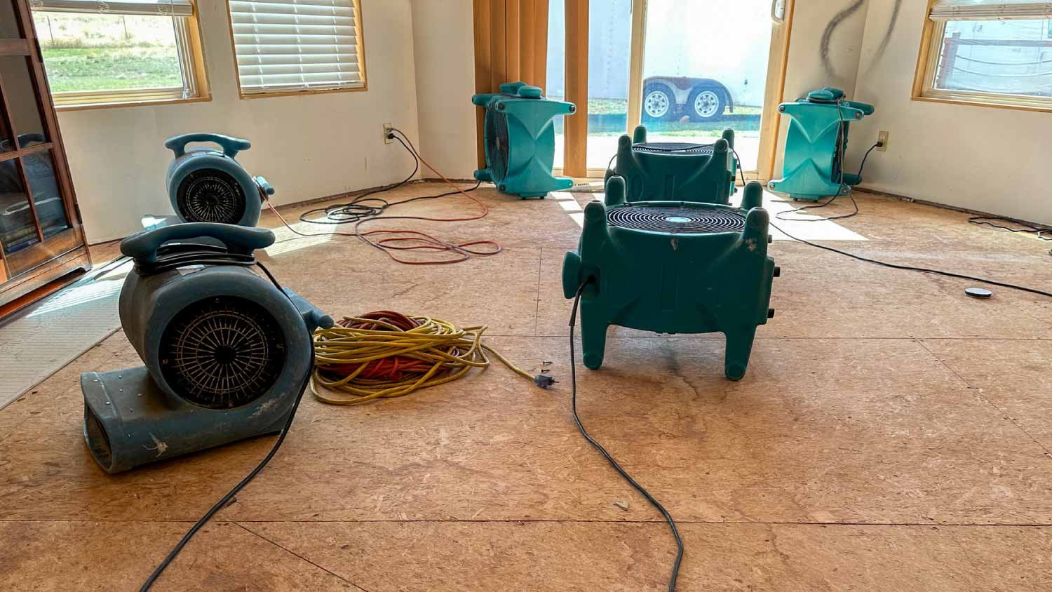 Air movers and a dehumidifier set up in a room during structural drying